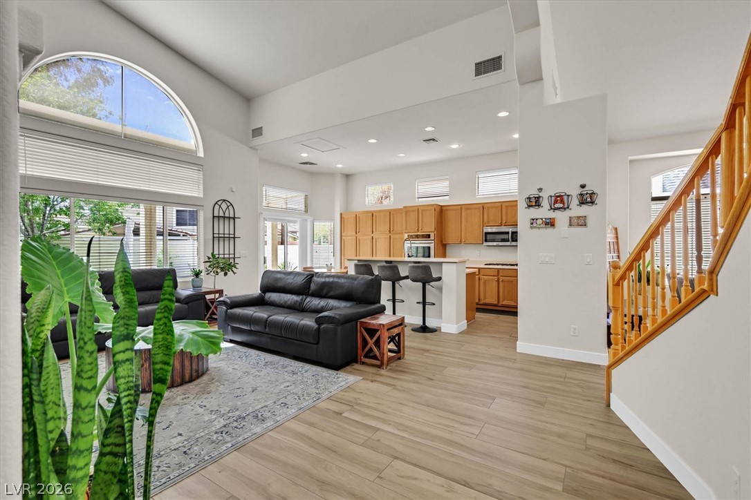 1259 Moon Vision Street Henderson, NV 89052 - Photo 6 of 53 An airy living area with soaring ceilings and abundant natural light flows seamlessly into a well-appointed kitchen.
