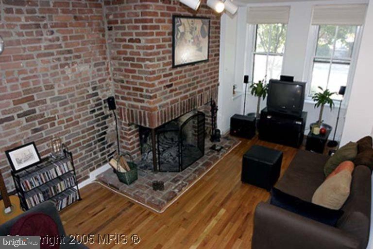a living room with furniture wooden floor and a fireplace