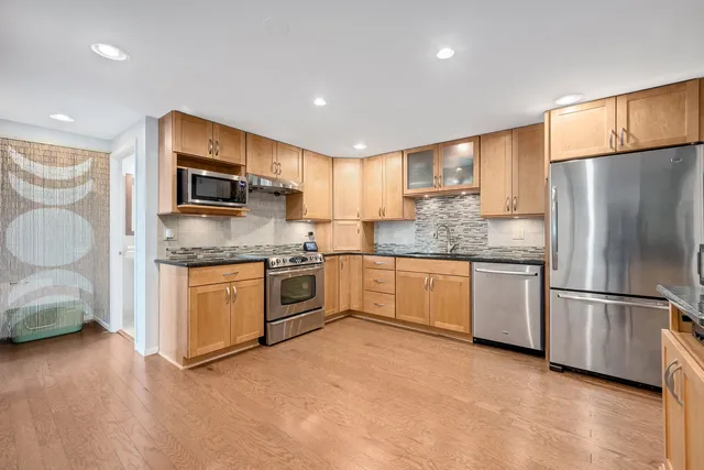 a kitchen with stainless steel appliances granite countertop a refrigerator sink and microwave