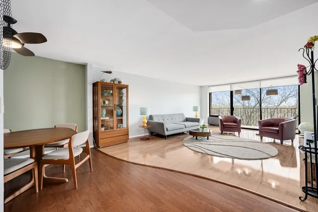 a living room with furniture a flat screen tv and a large window