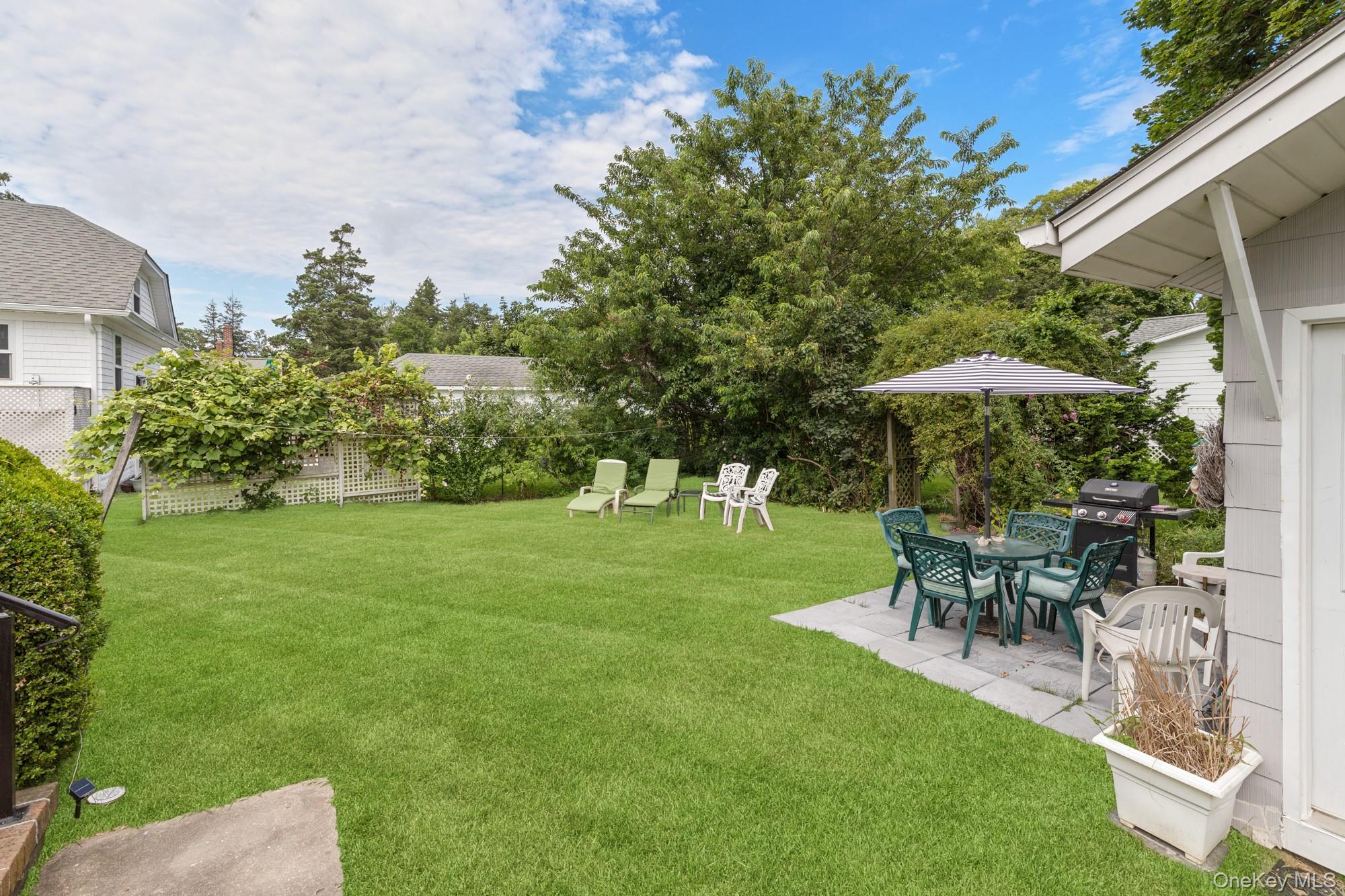 64 Point Street South Jamesport, NY 11970 - Photo 20 of 29 a view of a table and chairs under an umbrella