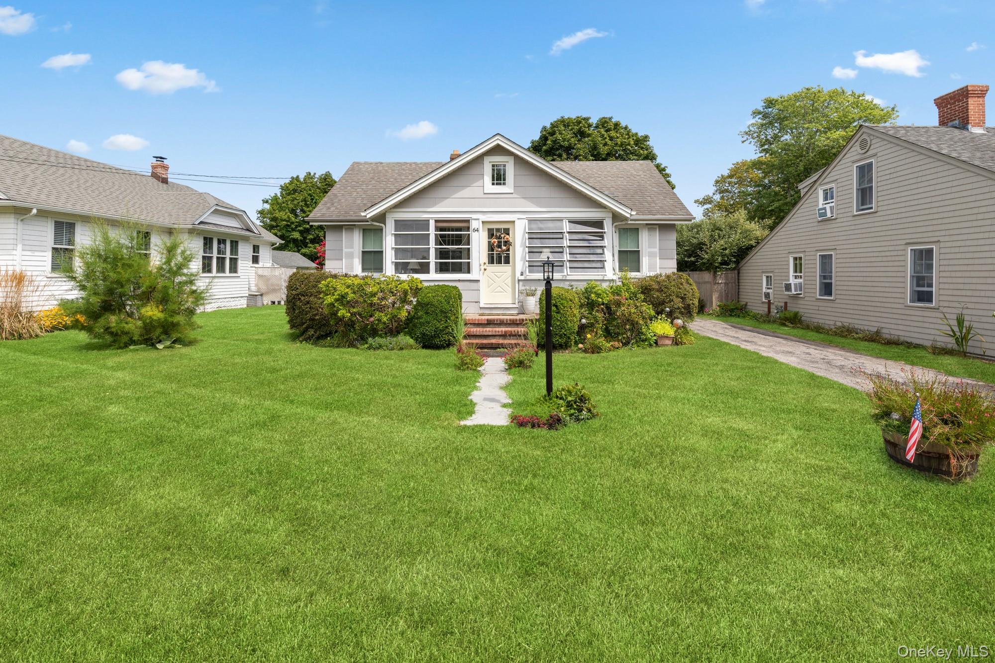64 Point Street South Jamesport, NY 11970 - Photo 2 of 29 a front view of a house with a yard and garage