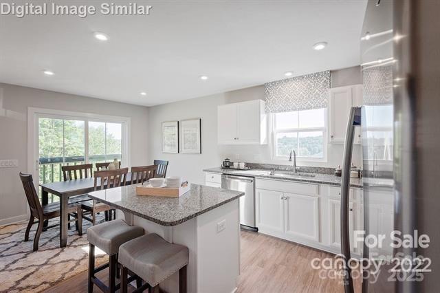 997 Pemberley Street, Unit 3177 Lancaster, SC 29720 - Photo 3 of 12 a kitchen with granite countertop sink dining table and chairs