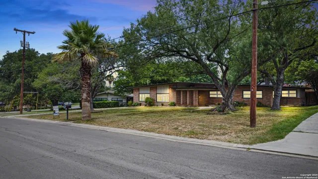 a view of a house with a yard and tree s
