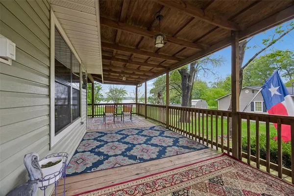 a view of a porch with furniture and wooden floor
