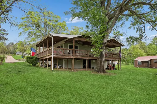 a view of a lake with a big yard and large trees