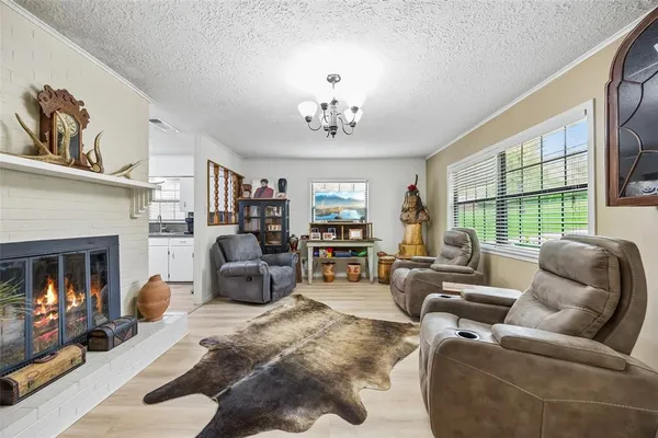 a living room with furniture a fireplace and a large window