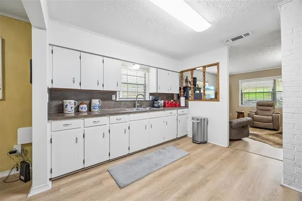 a kitchen with granite countertop white cabinets and white appliances
