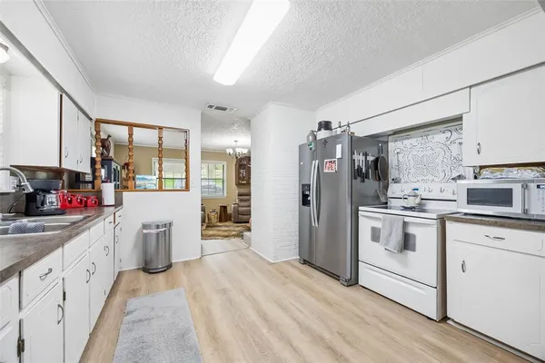a kitchen with white cabinets and white appliances