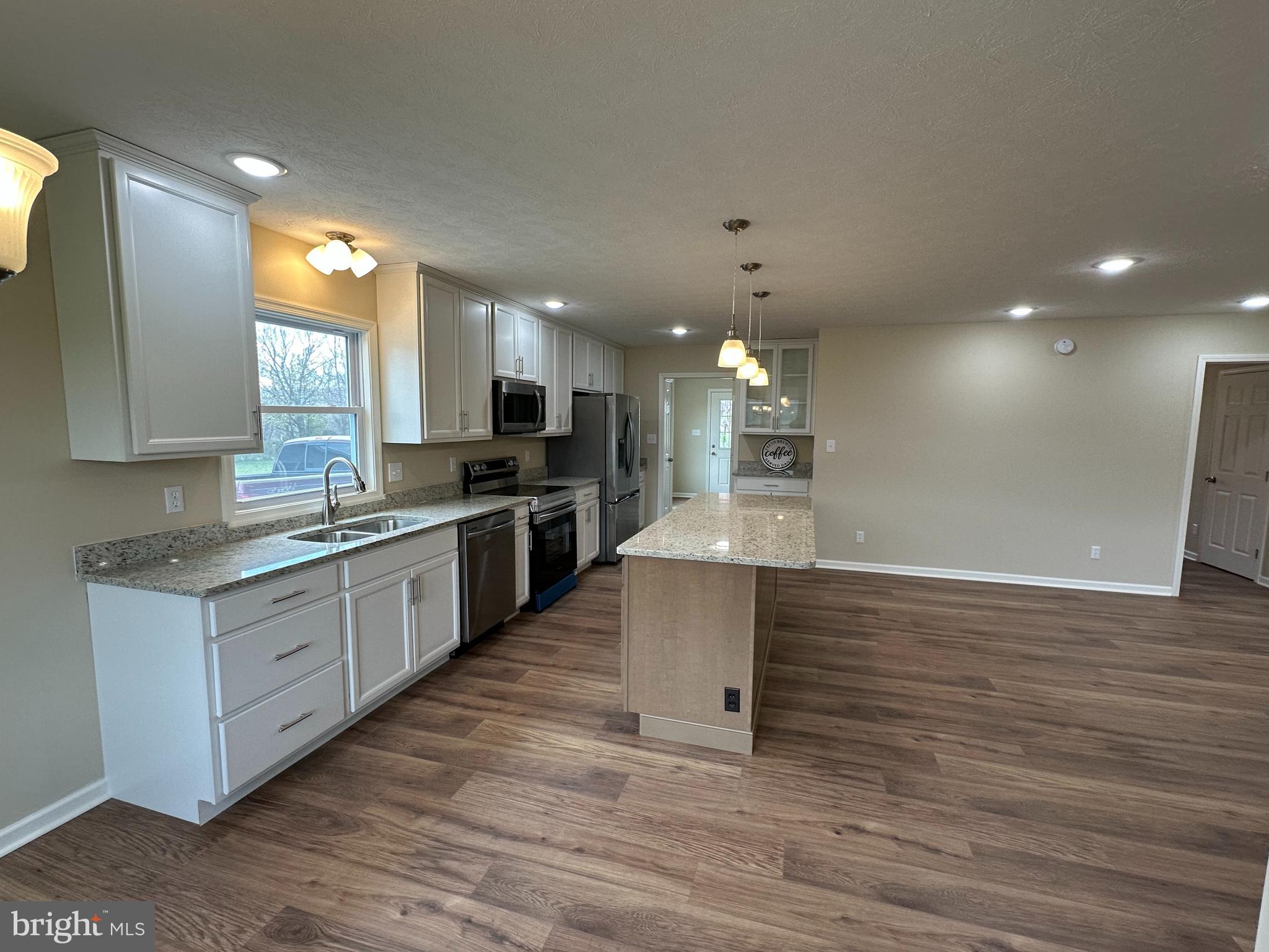 218 Honeyville Road Stanley, VA 22851 - Photo 11 of 27 a large kitchen with stainless steel appliances a large counter top a stove and a refrigerator