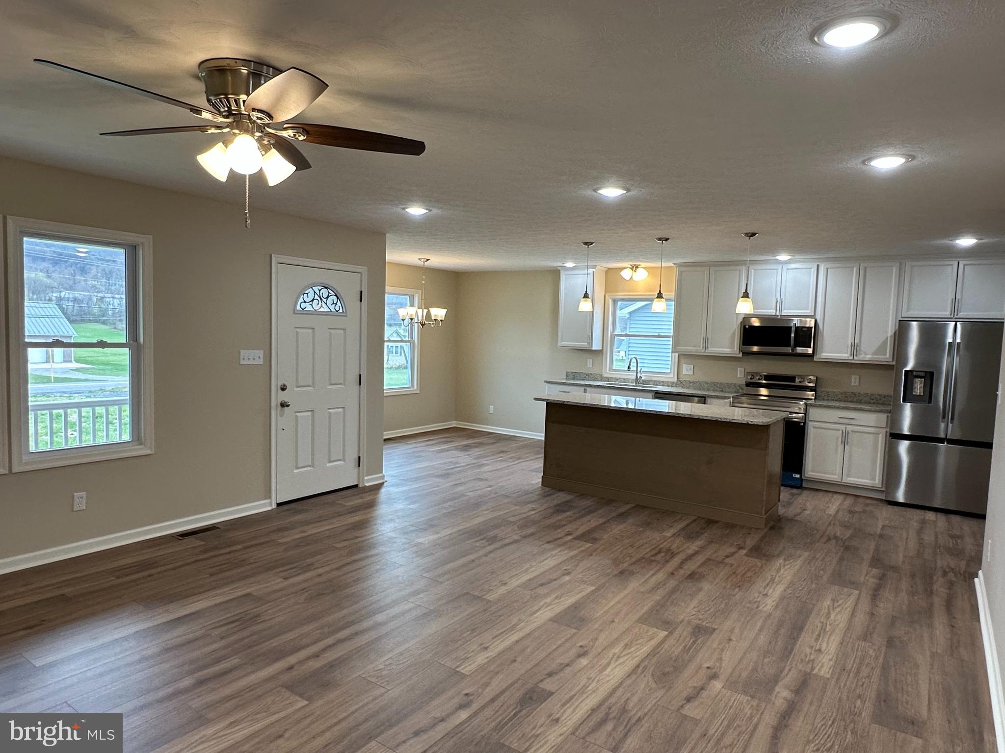 218 Honeyville Road Stanley, VA 22851 - Photo 6 of 27 a kitchen with stainless steel appliances granite countertop a refrigerator a sink dishwasher a stove with wooden cabinets and floor