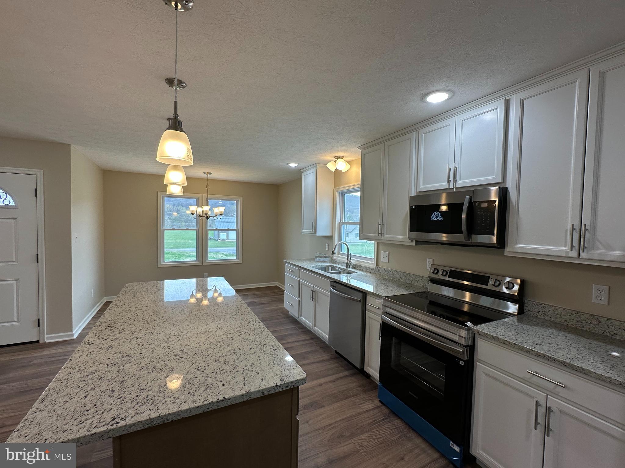 218 Honeyville Road Stanley, VA 22851 - Photo 8 of 27 a kitchen with stainless steel appliances granite countertop a sink a stove and a wooden cabinets