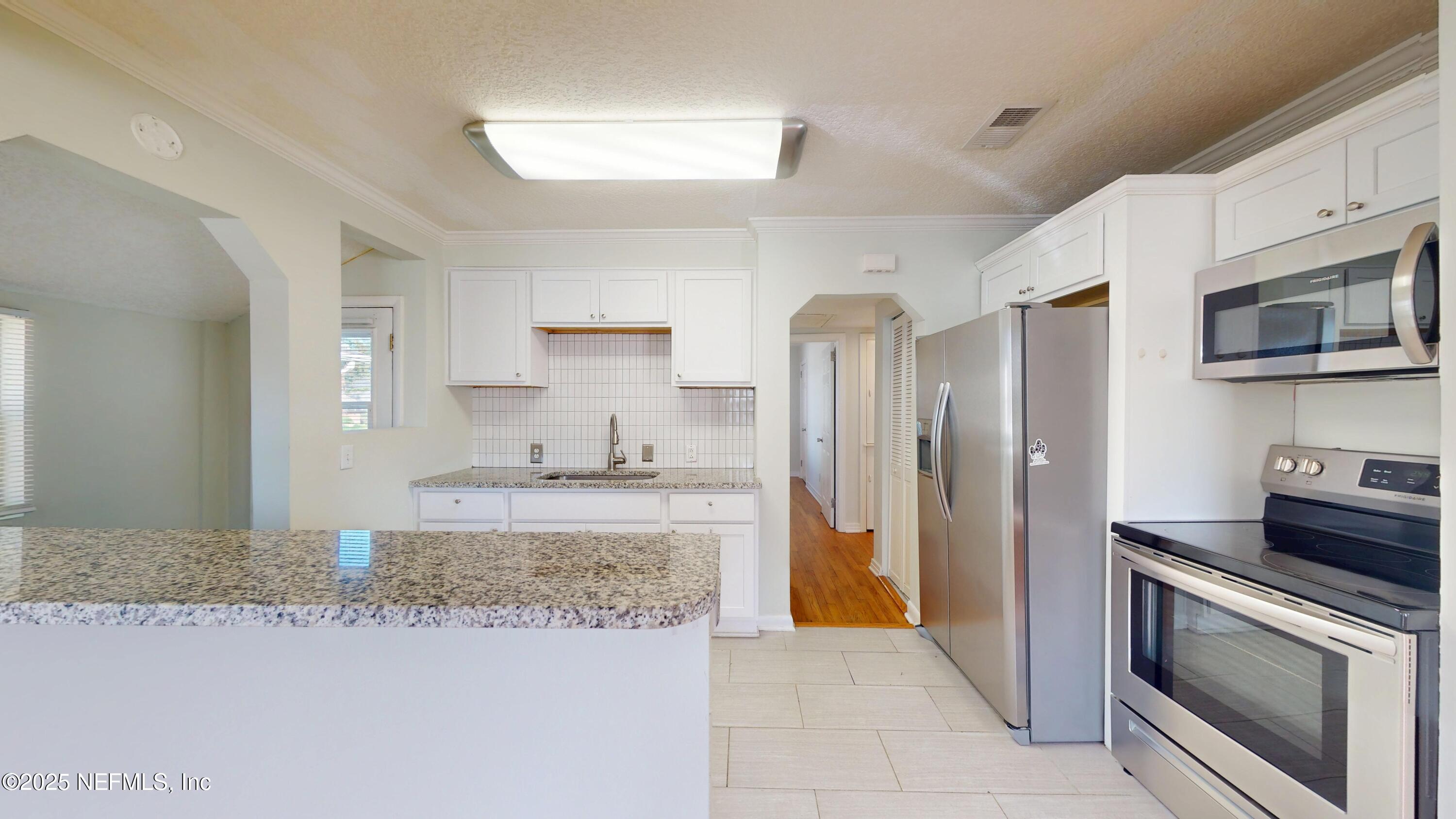 4547 Post Street Jacksonville, FL 32205 - Photo 11 of 23 a kitchen with stainless steel appliances granite countertop a refrigerator stove and sink