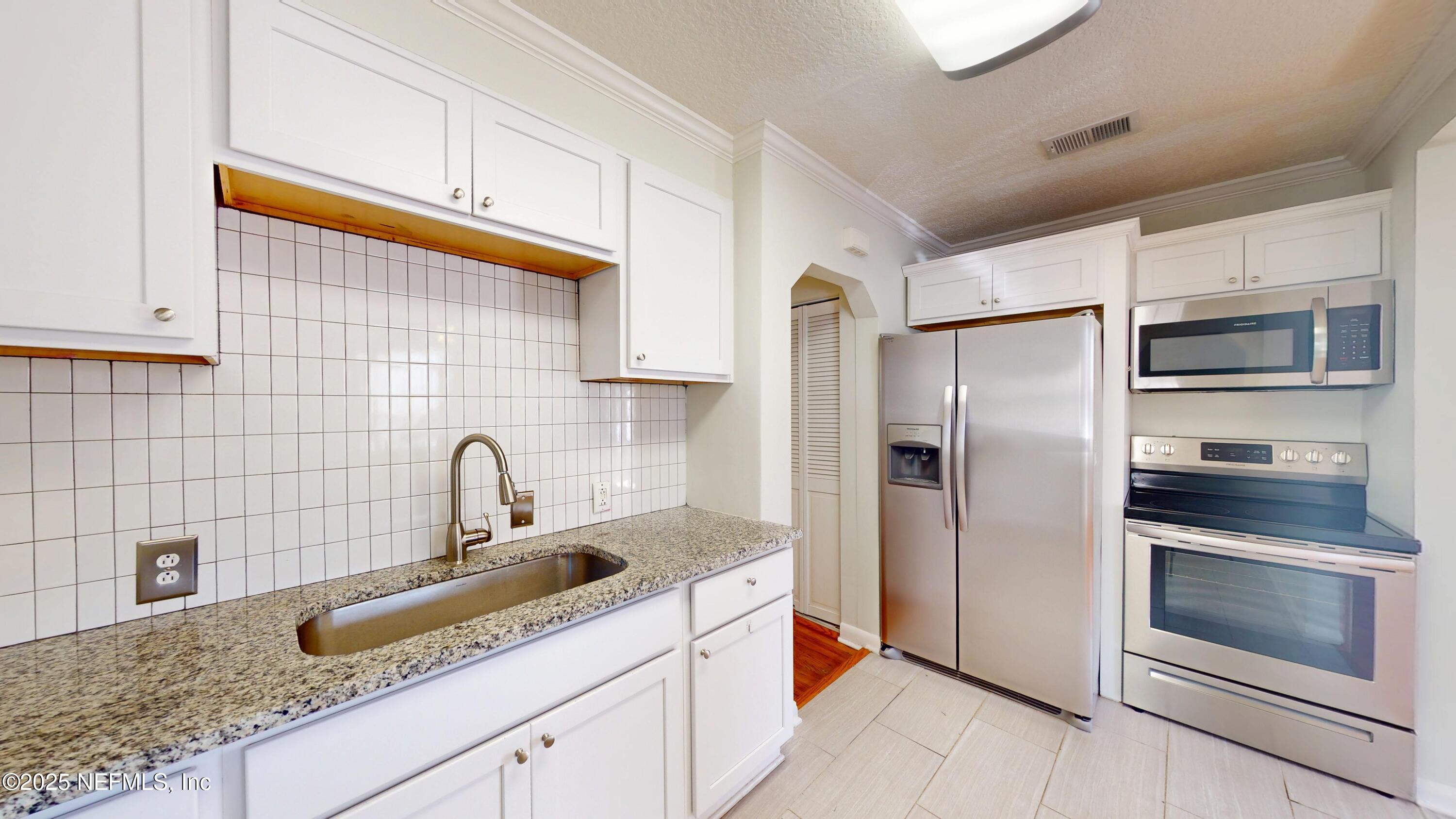 4547 Post Street Jacksonville, FL 32205 - Photo 14 of 23 a kitchen with stainless steel appliances granite countertop a sink stove and refrigerator
