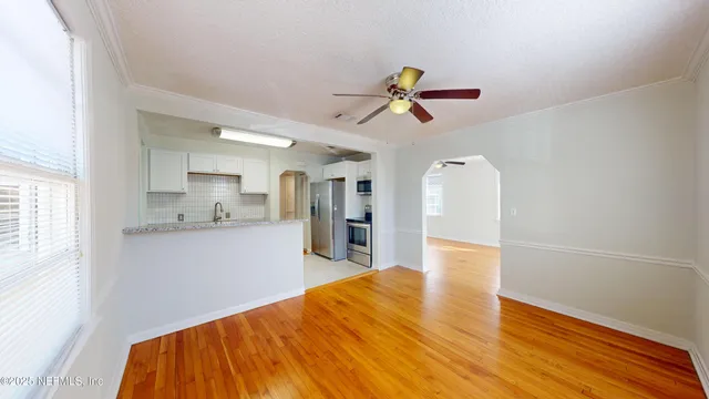 a view of a kitchen with a sink and wooden floor