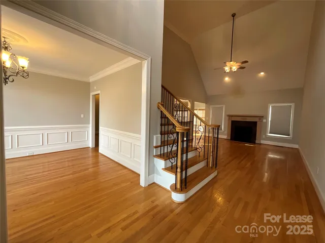 a view of a livingroom with wooden floor and a ceiling fan