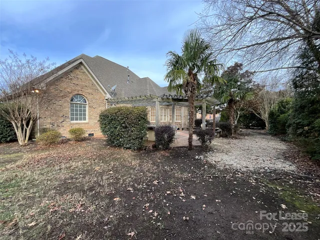 a view of a house with a yard and large tree