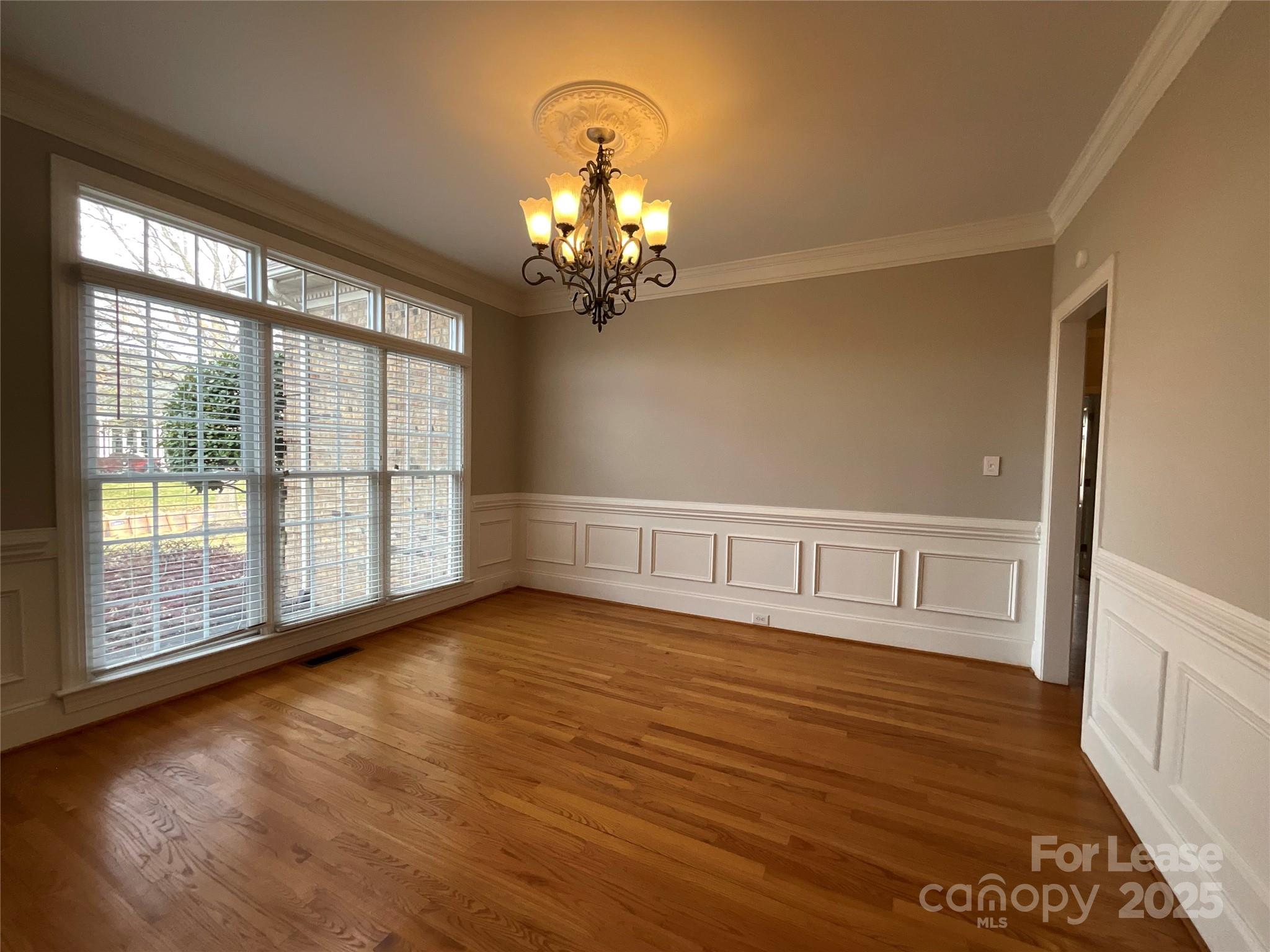 3100 Sea Island Lane Harrisburg, NC 28075 - Photo 3 of 30 a view of an empty room with wooden floor and a window