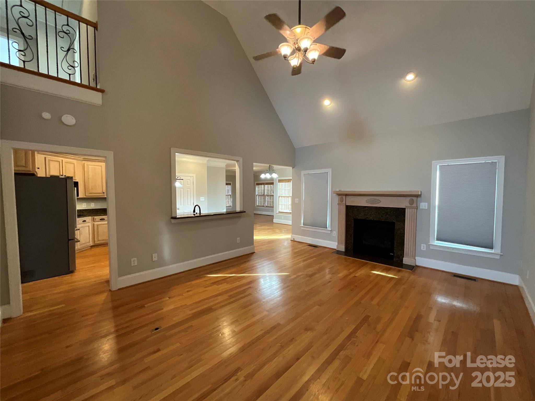 3100 Sea Island Lane Harrisburg, NC 28075 - Photo 5 of 30 a view of an empty room with wooden floor and a fireplace