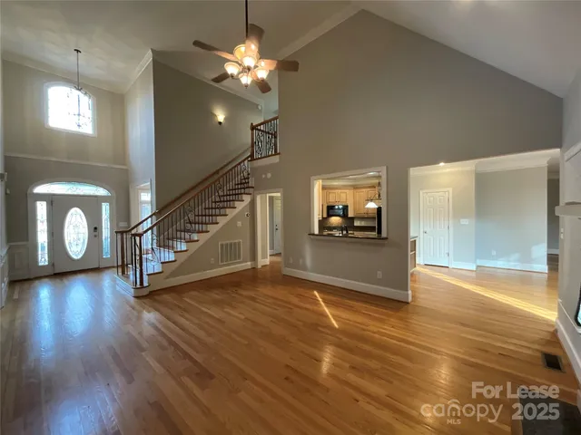 a view of a hallway with wooden floor and staircase