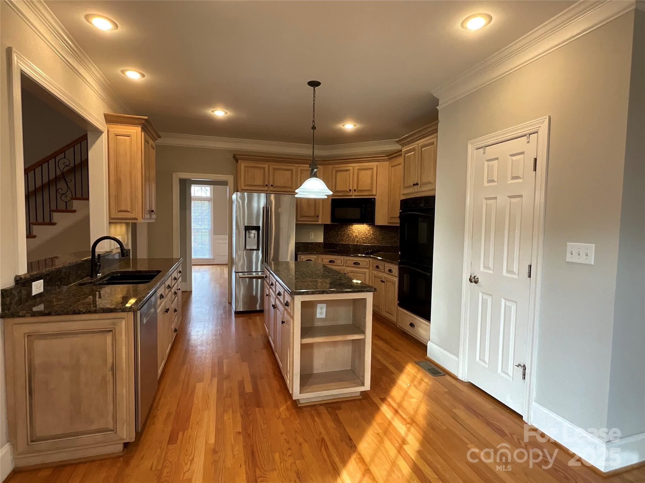 3100 Sea Island Lane Harrisburg, NC 28075 - Photo 7 of 30 a large kitchen with stainless steel appliances granite countertop a large stove top oven a sink dishwasher and wooden cabinets with wooden floor