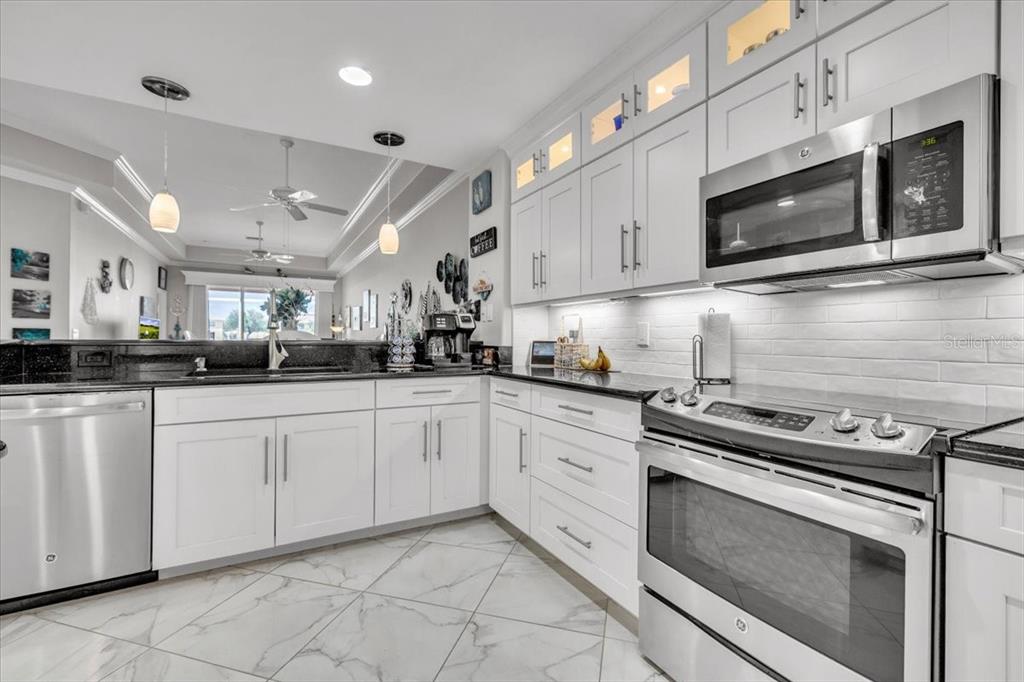 1260 Rio De Janeiro Avenue, Unit 102 Punta Gorda, FL 33983 - Photo 17 of 46 a kitchen with stainless steel appliances granite countertop a stove microwave and cabinets