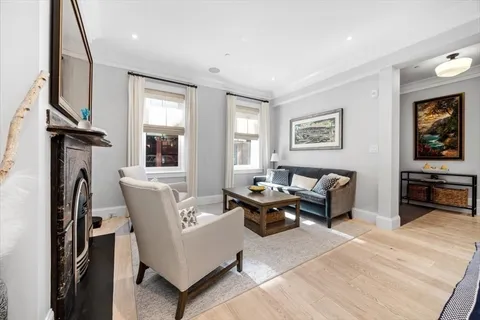 a living room with furniture a window and a flat screen tv