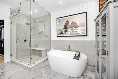 a white bath tub sitting next to a bathroom