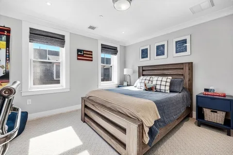 a bedroom with a bed next to a window and a bookshelf