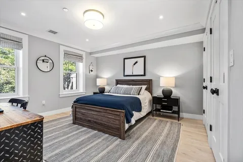 a spacious bedroom with a bed and a chandelier