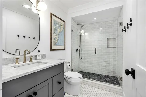 a bathroom with a sink a toilet and shower