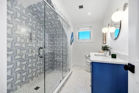 a bathroom with a sink a mirror a vanity and shower