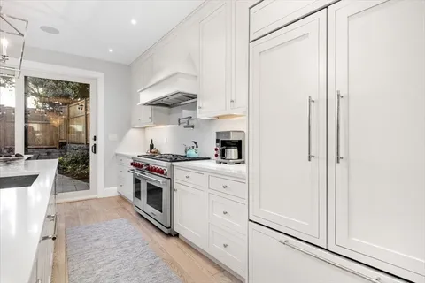 a kitchen with white cabinets and appliances