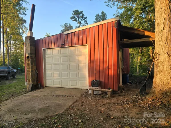 a view of a backyard with barn and a large tree