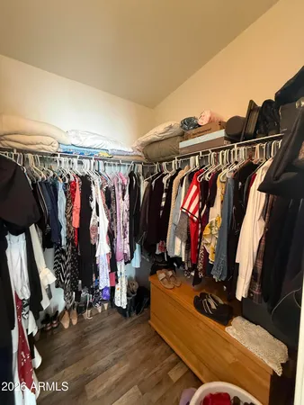 a view of walk in closet with clothes and shoes