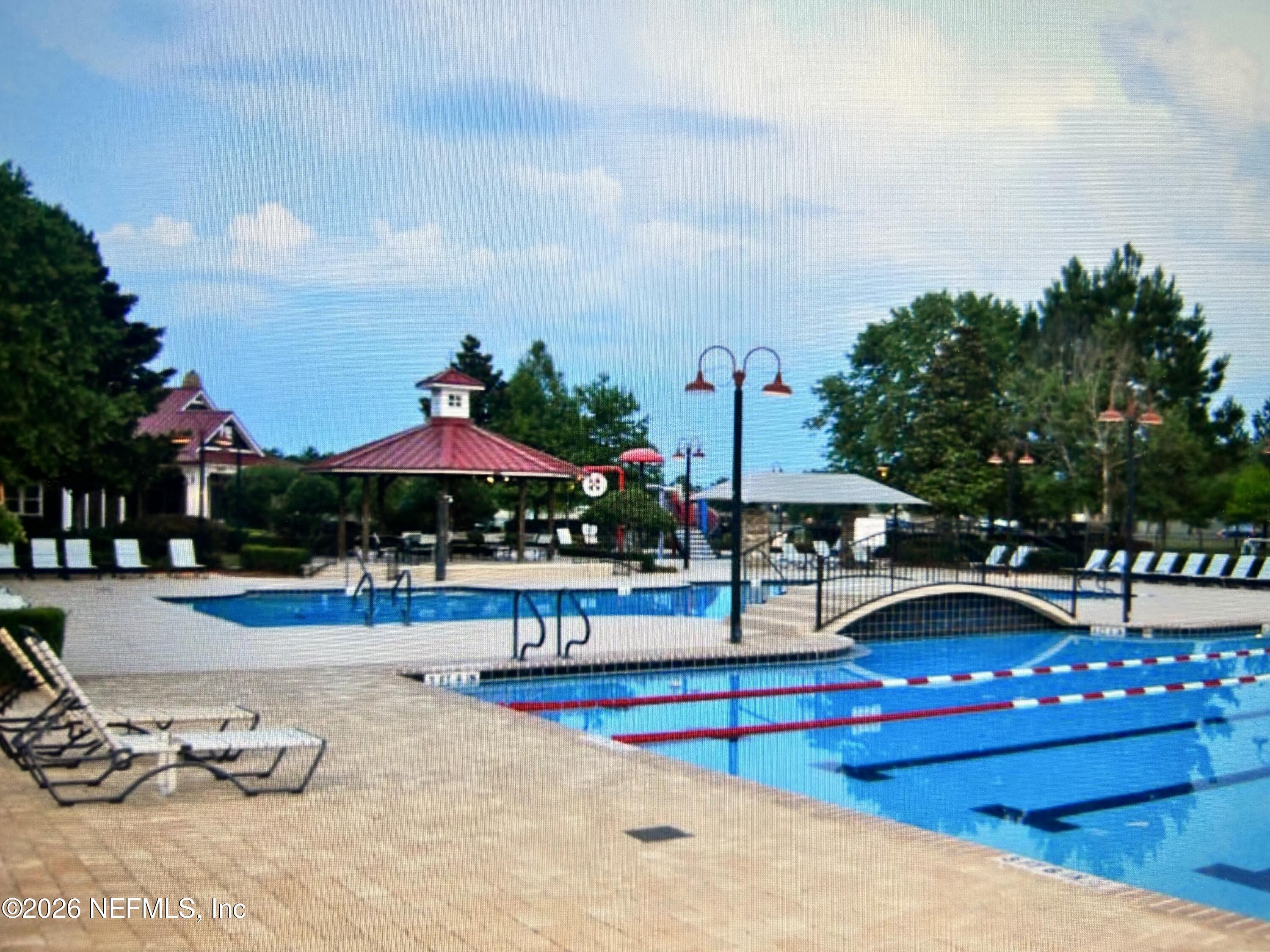 8629 Ribbon Falls Lane Jacksonville, FL 32244 - Photo 33 of 39 a view of swimming pool with outdoor seating and trees in the background