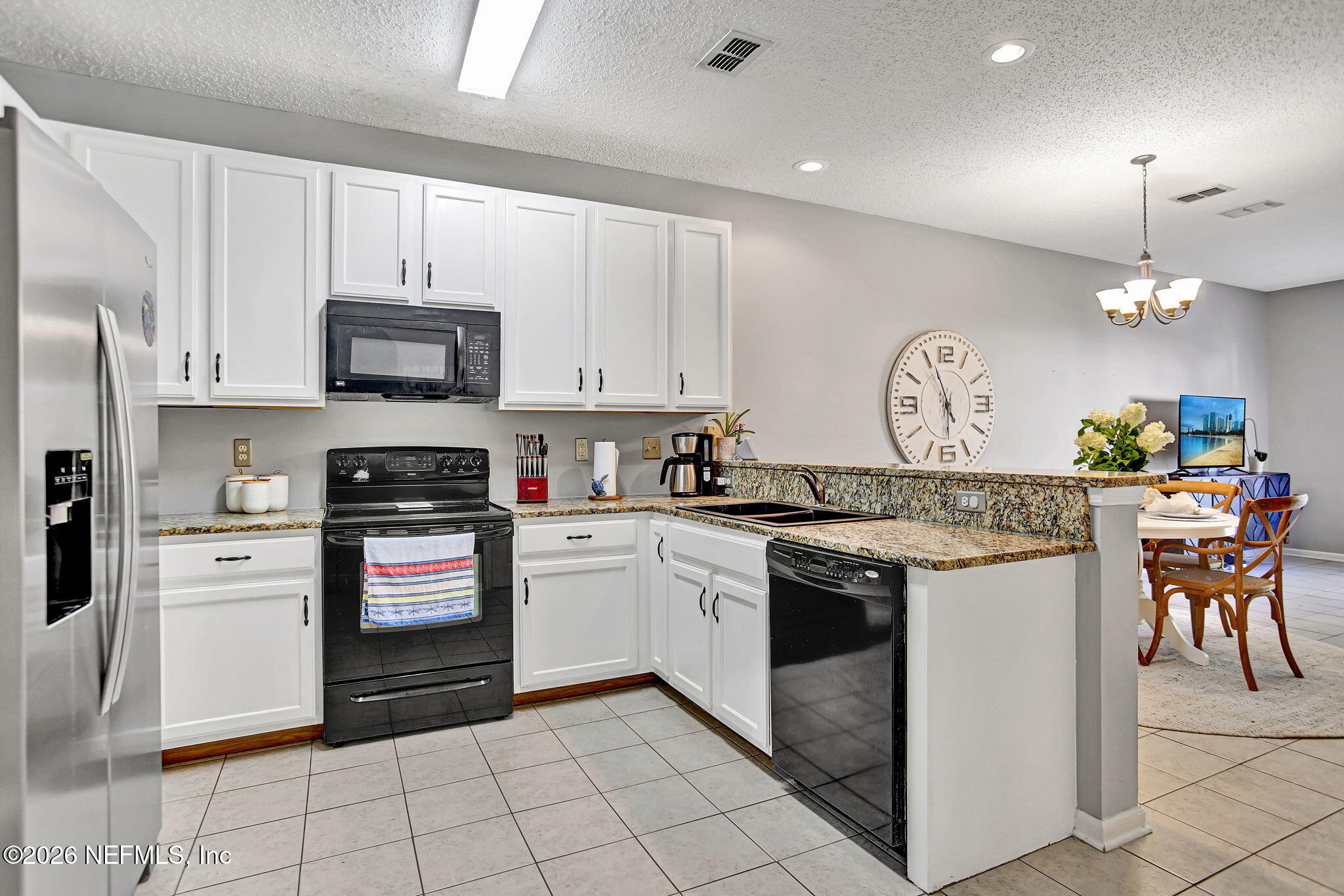8629 Ribbon Falls Lane Jacksonville, FL 32244 - Photo 4 of 39 a kitchen with stainless steel appliances granite countertop a stove top oven a sink dishwasher and a refrigerator with wooden cabinets