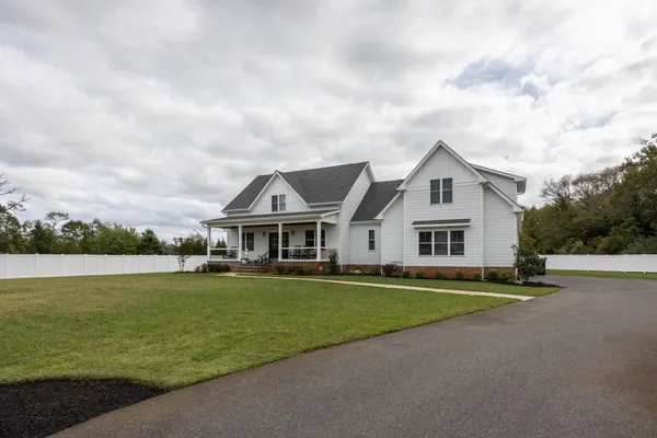 a view of a house with a big yard and sitting area