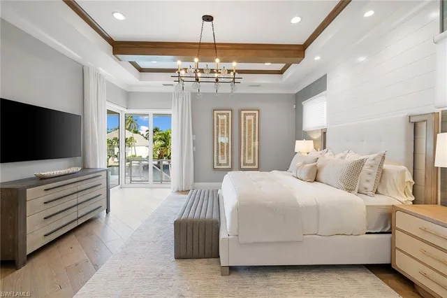 a bedroom with a bed and a chandelier
