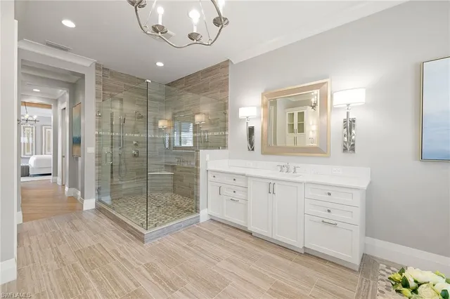 a spacious bathroom with a granite countertop sink a mirror and shower