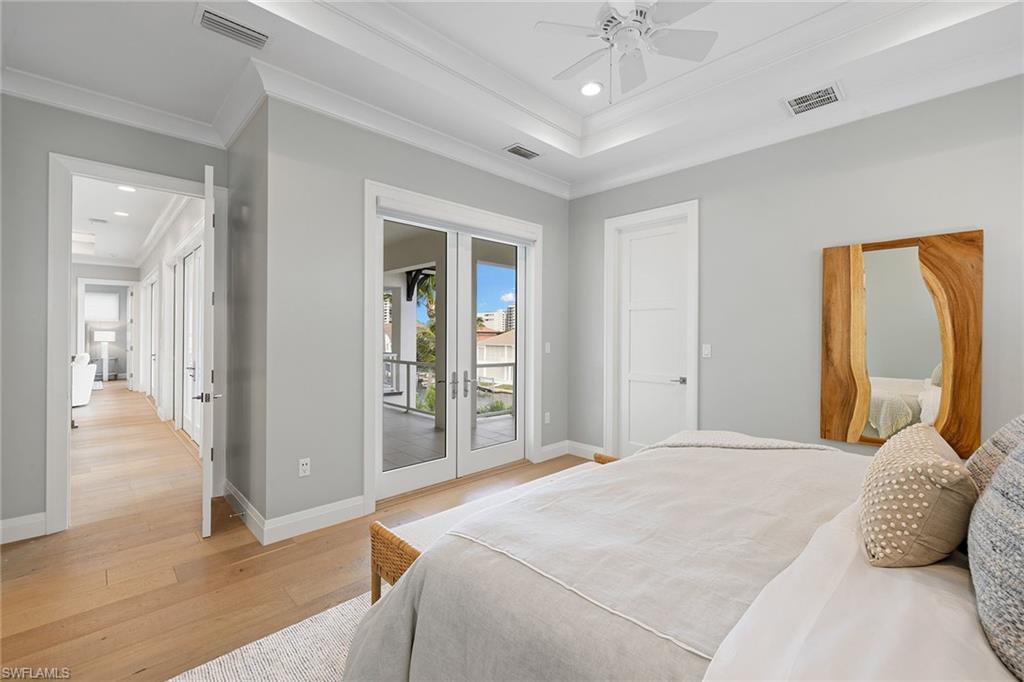 175 Conners Avenue Naples, FL 34108 - Photo 29 of 49 a bedroom with a bed and a chandelier