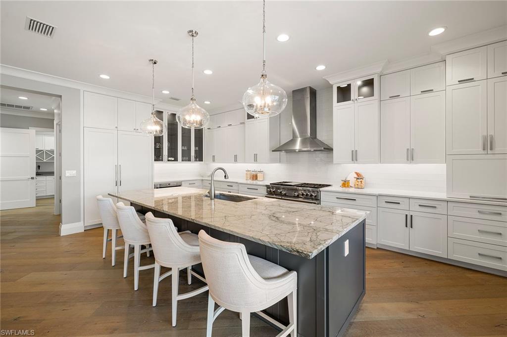 175 Conners Avenue Naples, FL 34108 - Photo 3 of 49 a kitchen with kitchen island granite countertop a sink and white cabinets