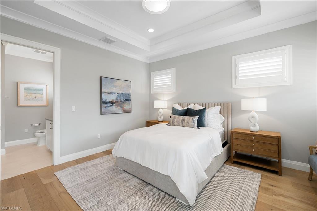 175 Conners Avenue Naples, FL 34108 - Photo 31 of 49 a bedroom with a bed and wooden floor