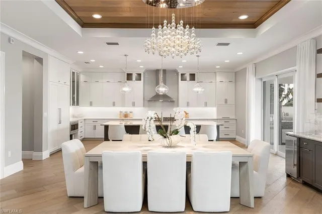a large white kitchen with a large counter top appliances and cabinets