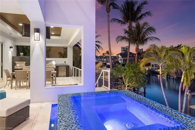 a view of a chairs with flower plants in front of house