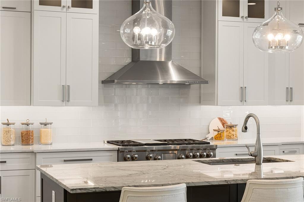 175 Conners Avenue Naples, FL 34108 - Photo 7 of 49 a kitchen with a stove and cabinets