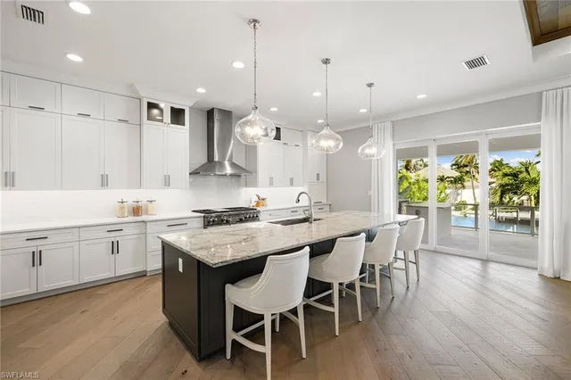a kitchen with a dining table chairs stove and white cabinets