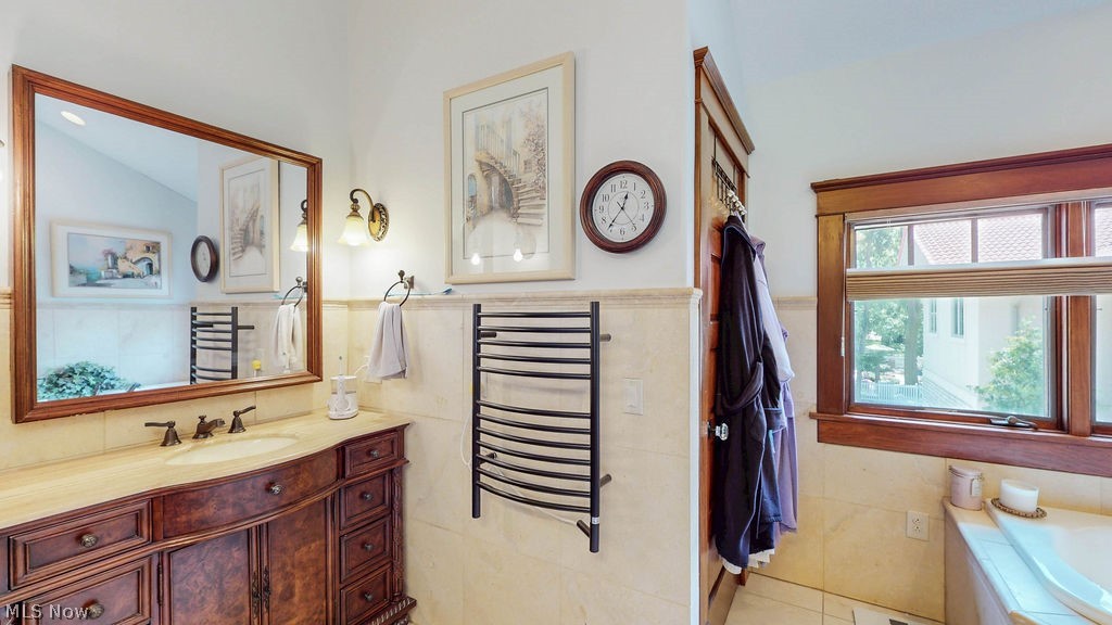 1431 Cedar Point Road Sandusky, OH 44870 - Photo 30 of 50 Bathroom featuring vanity, tile walls, a garden tub, a wainscoted wall, and tile patterned flooring