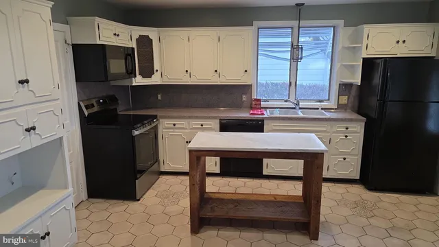 a kitchen with a stove a refrigerator and a microwave