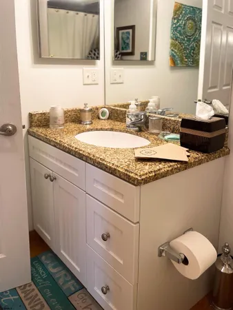 a bathroom with a granite countertop toilet sink and mirror